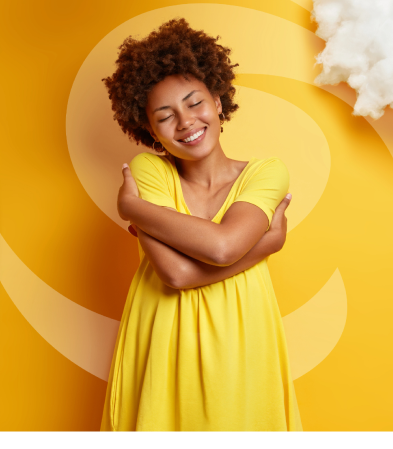 Young Black woman with auburn afro in a yellow shirt against yellow backdrop, hugging herself with dreamlike clouds around her head.