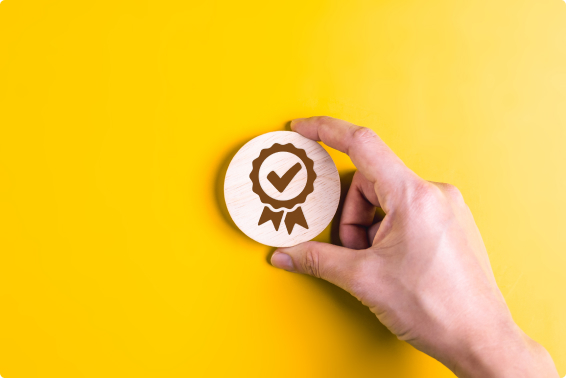 Yellow background with a white hand holding a wooden symbol signifying that you’ve been pre-qualified for a loan.