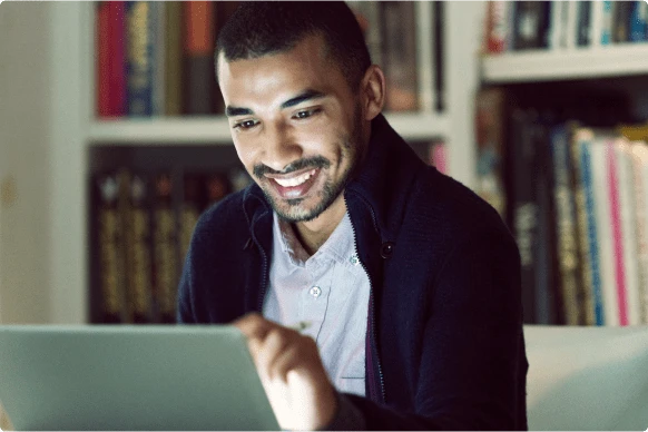 Man sitting looking at laptop smiling