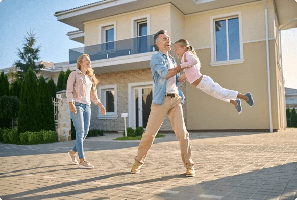 Family playing with their child in the backyard smiling